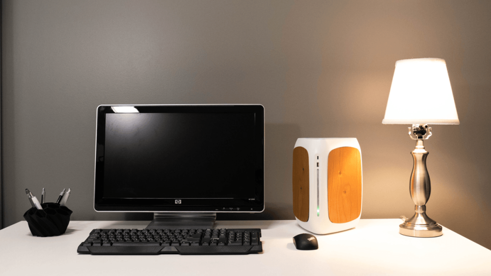 A desk with a computer and lamp